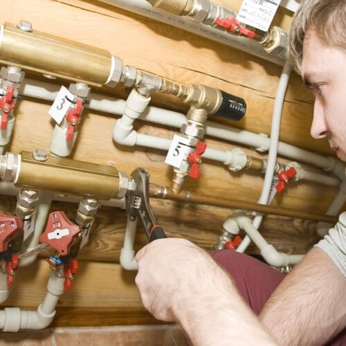 Plumber At Work Plumber at work. Servicing water & heating systems