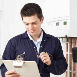 Male Plumber Working On Central Heating Boiler